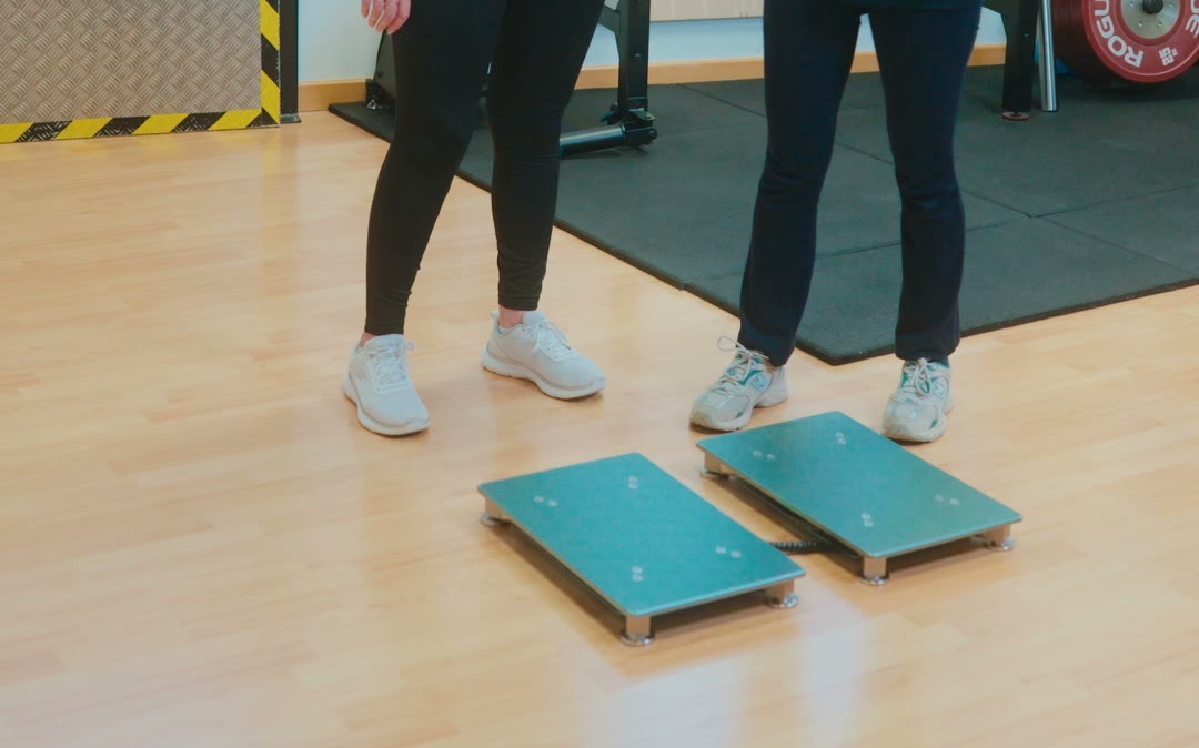 Los pies de una mujer sobre dos plataformas de medición, en la sala de la clínica