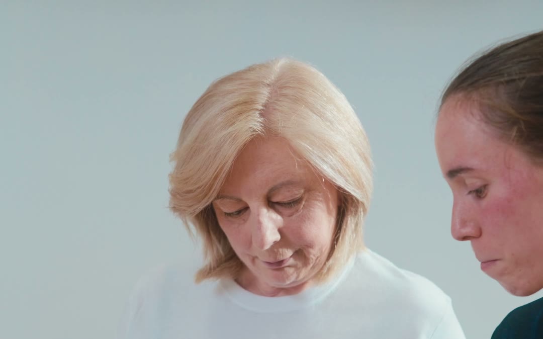 Mujer leyendo un folleto de resultados junto a una fisioterapeuta